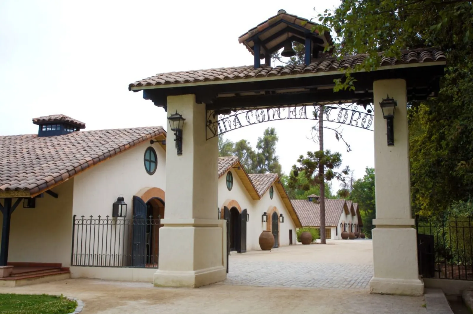 Arched gateway with Viña Concha y Toro ironwork lettering and whitewashed cellar buildings
