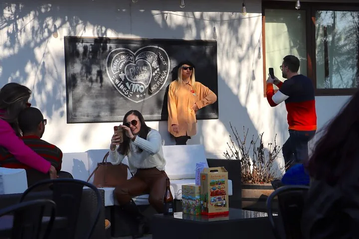 Visitors taking photos on a patio in front of an Undurraga chalkboard mural