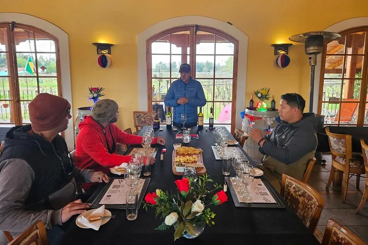 Small group seated at a long tasting table in a yellow-walled room